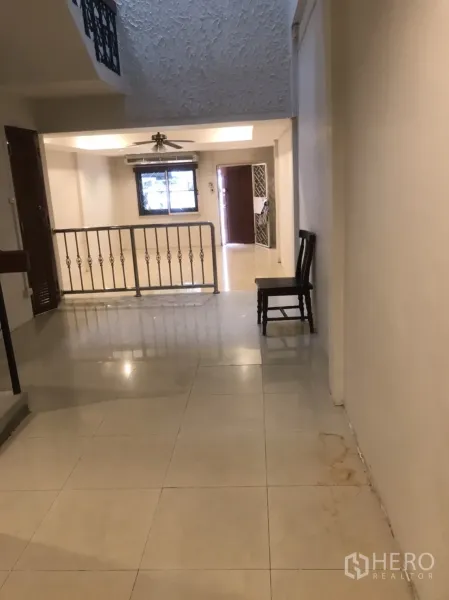 Home Office for rent in Khlong Toei, Bangkok - Open landing with textured high ceiling, window, and front entry separated by a metal balustrade.