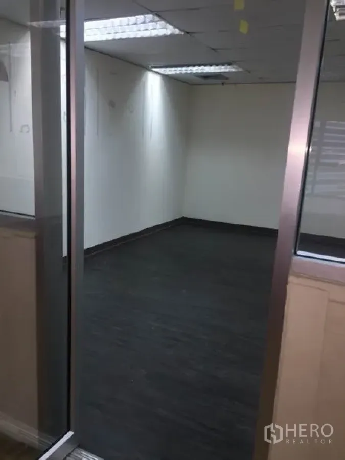 สำนักงาน ให้เช่าในWatthana, Bangkok - ห้องทำงานว่างกั้นด้วยกระจก พื้นสีเข้ม ผนังสีขาว และไฟฟลูออเรสเซนต์บนเพดาน