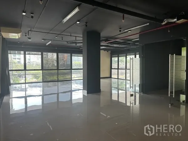 办公空间 出租在Khlong Toei, Bangkok - 开放式办公区，落地窗与亮面瓷砖地面，外露吊顶。