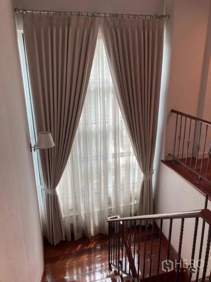 บ้าน ให้เช่าในMueang Nonthaburi, Nonthaburi - โถงบันไดมีหน้าต่างสูงติดผ้าม่าน มองเห็นสวนด้านนอก