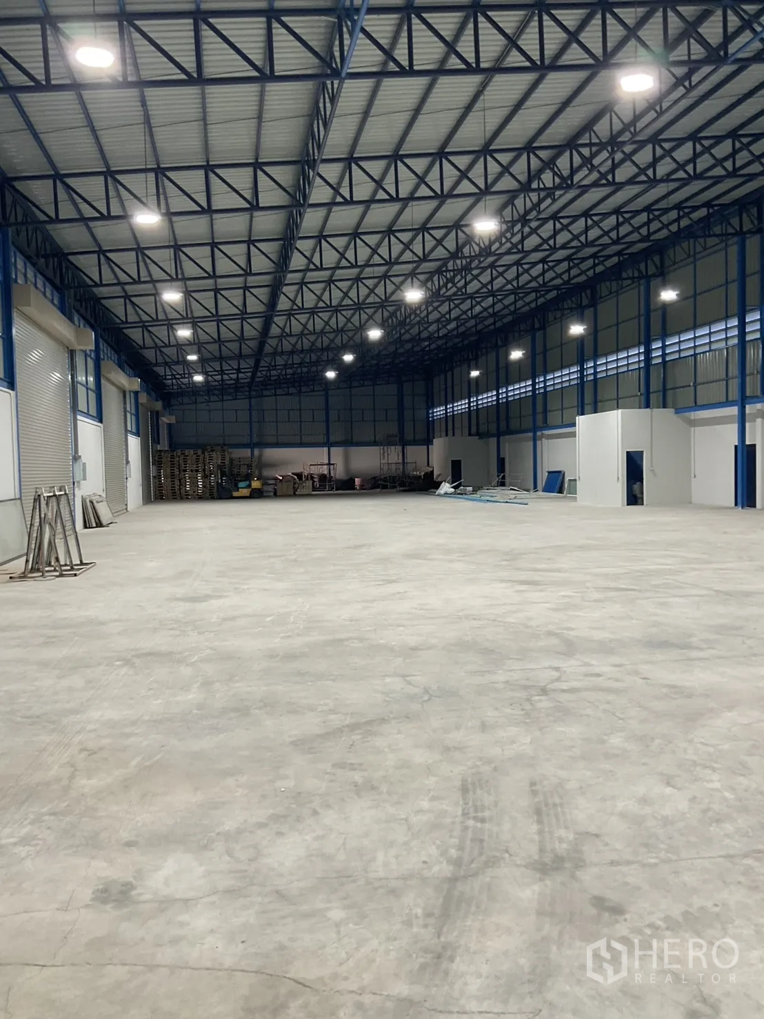 Warehouse for rent in Bang Bua Thong, Nonthaburi - Open warehouse interior with side office rooms and equipment area at the far end.