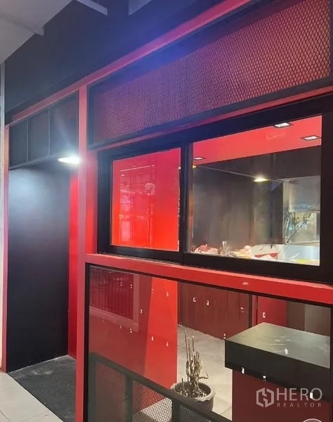 零售空间 出租在Watthana, Bangkok - 红黑色店面立面，配大面积展示橱窗与照明，靠近Asok，曼谷瓦塔那。