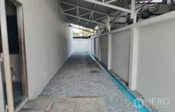 货栈 出租或出售在Prawet, Bangkok - 仓库侧边有顶通道，碎石地面与排水沟。