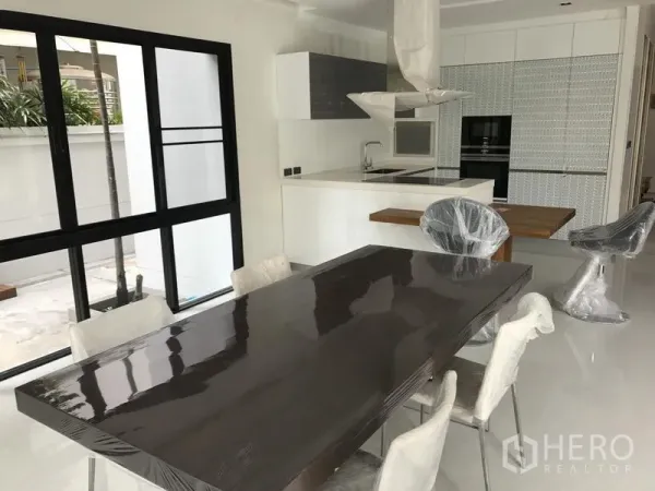 บ้าน ให้เช่าในBang Kapi, Bangkok - ห้องครัวแบบเปิดพร้อมไอส์แลนด์ เตาอบ และโต๊ะทานข้าวติดประตูกระจกบานเลื่อน