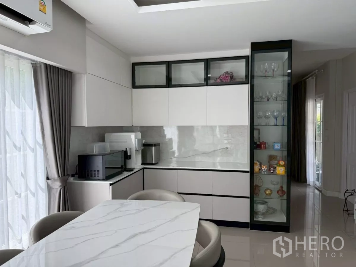 Detached House for rent in Bang Phli, Samut Prakan - Built-in pantry with white cabinets, marble-look countertop and glass display cabinet.