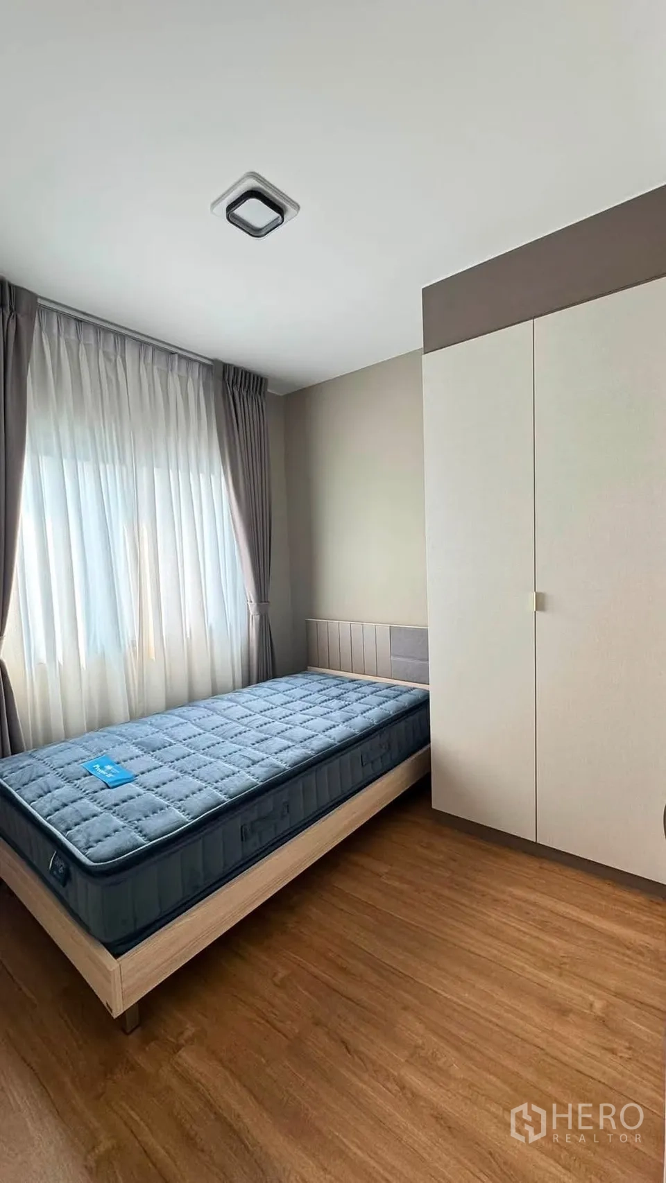 Townhouse for rent in Bang Phli, Samut Prakan - Bright bedroom with single bed, large window, sheer curtains and a wardrobe.