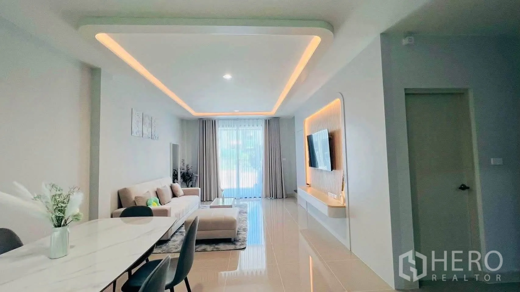 ทาวน์เฮาส์ for rent in Bang Phli, Samut Prakan - ผนังทีวีดีไซน์พร้อมไฟซ่อน มองสู่โถงรับแขกและมุมทานอาหารสว่างสดใส