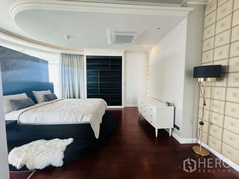 คอนโด ให้เช่าหรือขายในKhlong Toei, Bangkok - อีกมุมของห้องมาสเตอร์ เตียงบนแท่น ตู้บิลท์อินสีดำ โคมไฟยืน และพื้นไม้