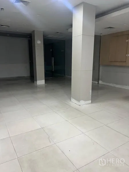 Shophouse for rent in Samphanthawong, Bangkok - Ground-floor tiled commercial hall with square columns and glass doors.