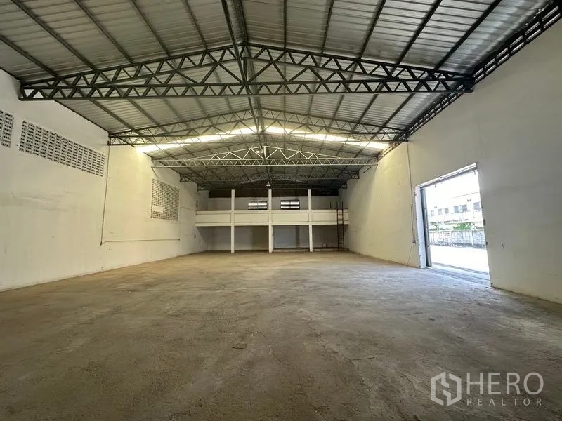 货栈 出租在Mueang Pathum Thani, Pathum Thani - 由内向装卸门方向的视角，采光充足，作业空间开阔。