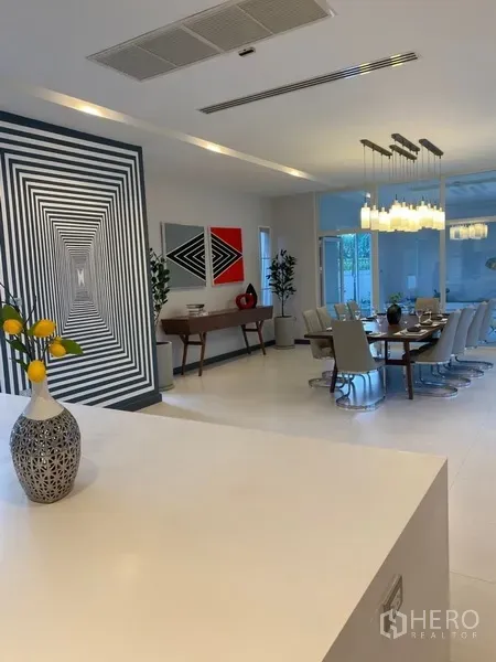 บ้าน ให้เช่าในSuan Luang, Bangkok - โถงรับประทานอาหารแบบโอเพ่น พร้อมไฟแขวนดีไซน์และงานศิลปะ ข้างหน้าต่างบานใหญ่