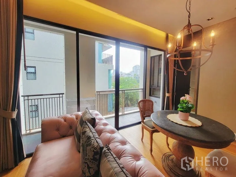 คอนโด ให้เช่าในWatthana, Bangkok - ห้องนั่งเล่นเปิดโล่ง ชุดโต๊ะทานอาหารพร้อมแชนเดอเลียร์ โซฟาหนังปุ่ม และประตูระเบียงกว้าง