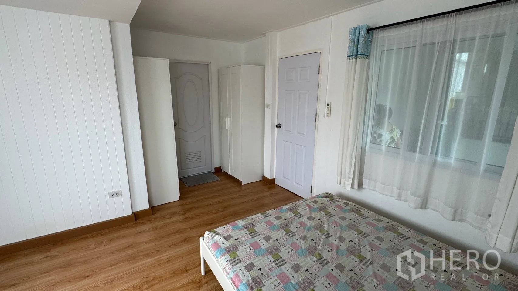 Detached House for rent in Saphan Sung, Bangkok - Bedroom corner showing wardrobes, doors, and a window with curtains.