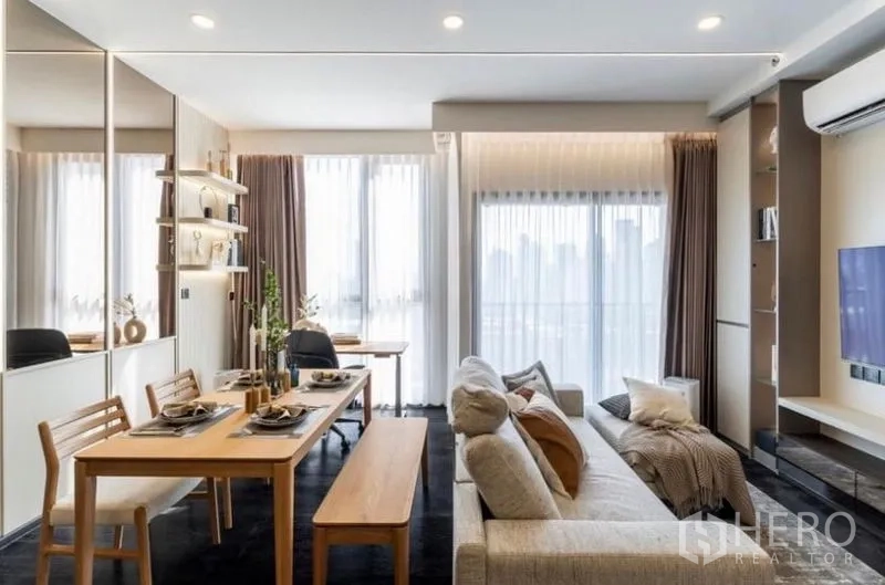 Condominium for sale in Watthana, Bangkok - Open living and dining room with floor-to-ceiling windows, balcony access and soft curtains