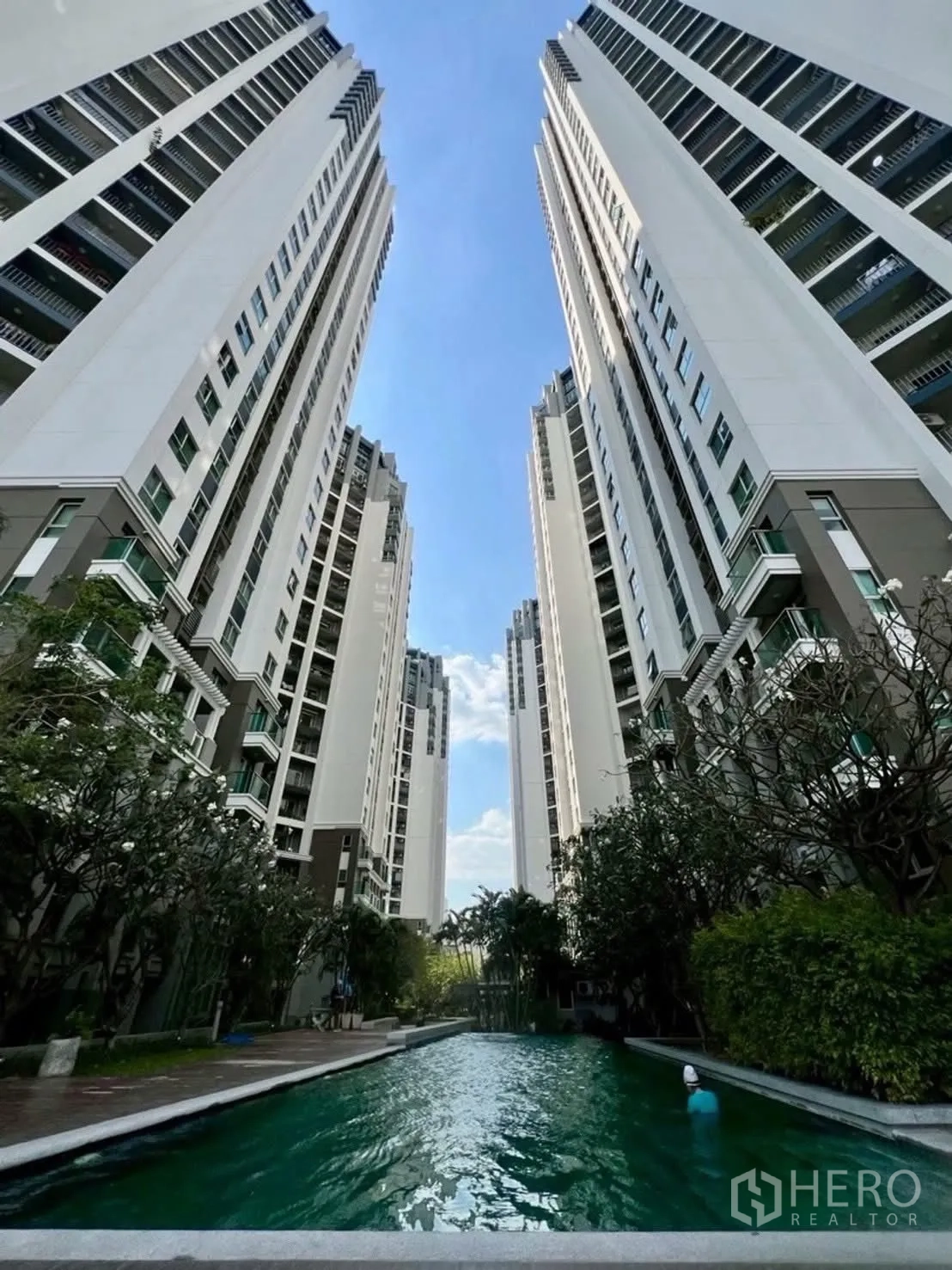 Condominium for rent in Huai Khwang, Bangkok - High-rise condominium towers framing a long lap pool.