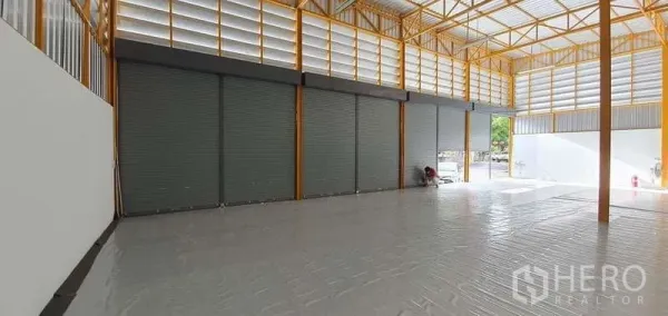 คลังสินค้า ให้เช่าในKhlong Toei, Bangkok - ฮอลล์เก็บสินค้ากว้าง มีประตูม้วนสีเทาเรียงกัน รับแสงธรรมชาติ เหมาะสำหรับขนถ่ายสินค้า