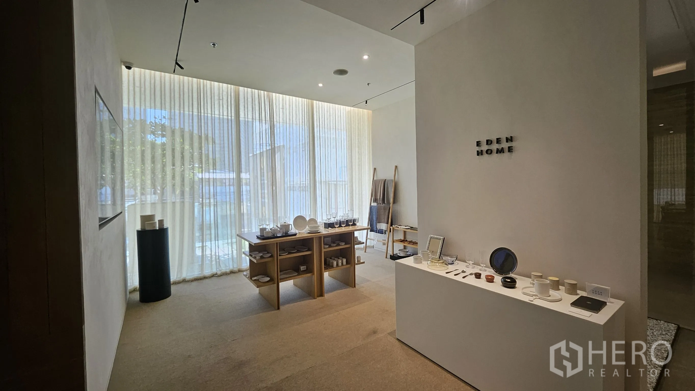 ออฟฟิศ for rent in Watthana, Bangkok - โซนสำนักงานสไตล์โชว์รูม รับแสงธรรมชาติด้วยผ้าม่านโปร่งและโต๊ะจัดแสดง.