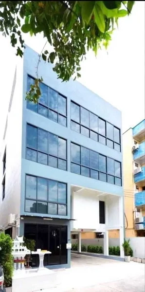 Office Space for rent or sale in Din Daeng, Bangkok - Modern multi-storey office building with large glass windows and a covered driveway in Din Daeng.