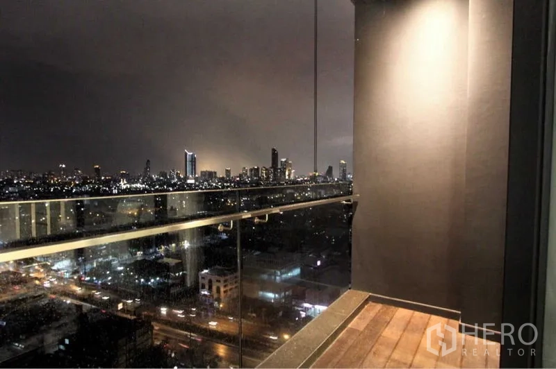 Condominium for rent in Bangkok - Private balcony with glass railing and dramatic night skyline views over Bangkok.