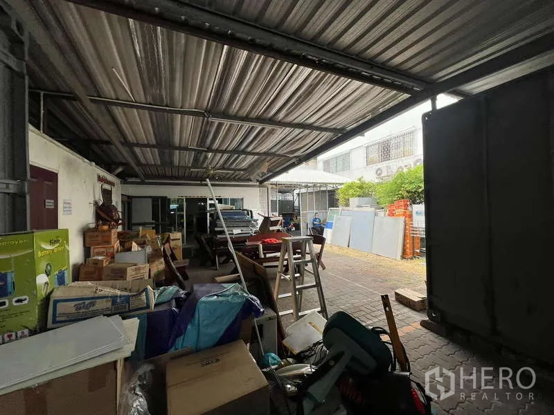Office Space for rent - Covered service yard used for storage beneath a metal roof.