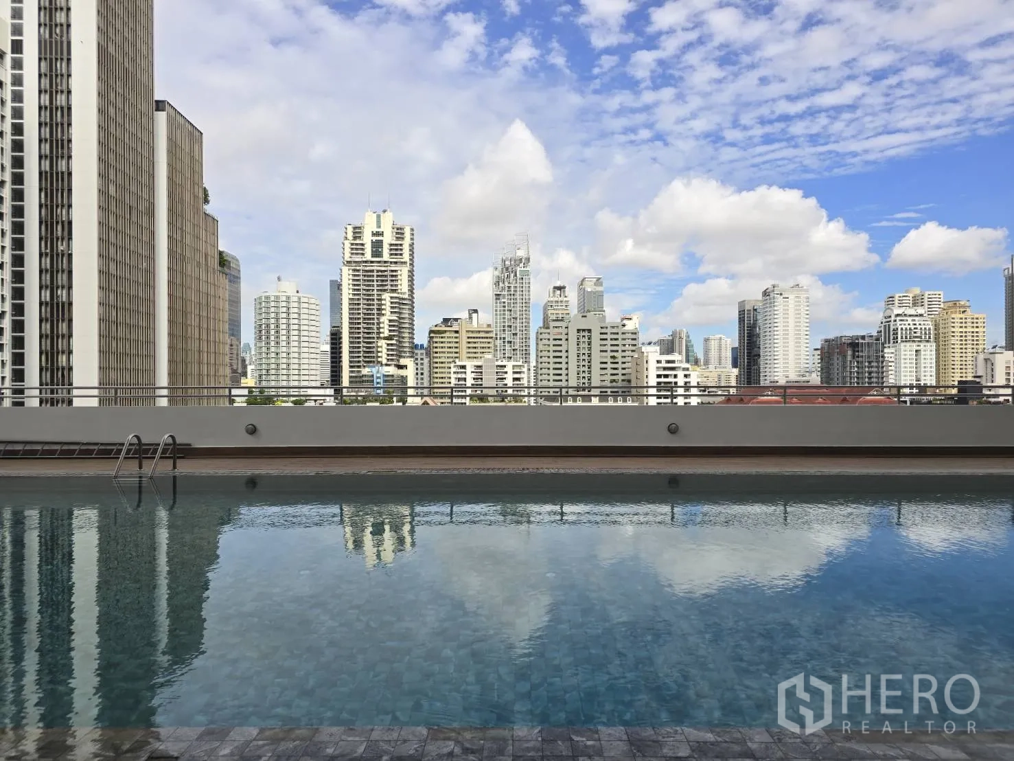 Office Space for rent in Watthana, Bangkok - Outdoor pool with Bangkok high-rise skyline under a blue sky.