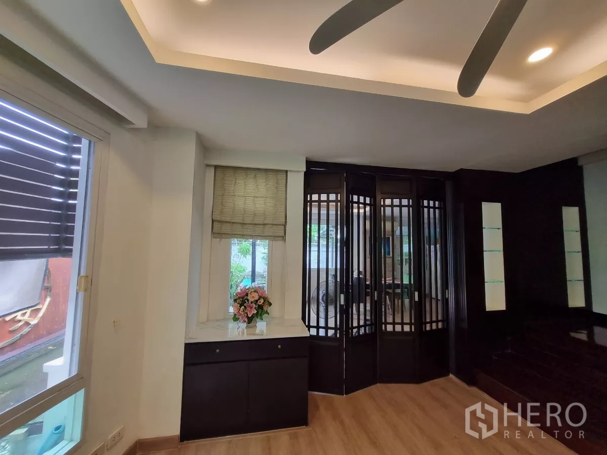 บ้าน ให้เช่าในBang Kapi, Bangkok - ห้องนั่งเล่นสไตล์โมเดิร์น พื้นไม้ พัดลมเพดาน และฉากกั้นกระจกบานพับ