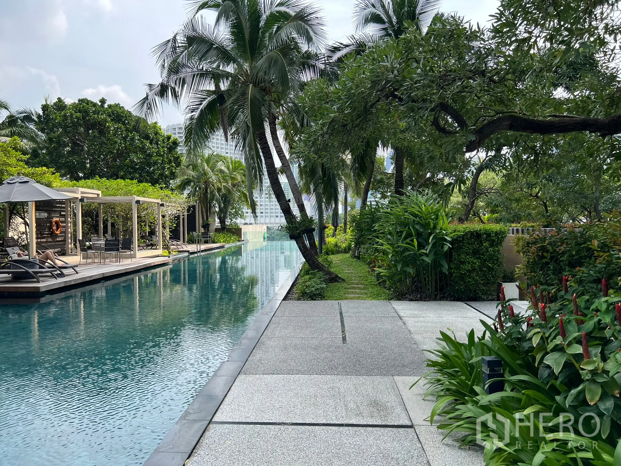 คอนโด ขายในKhlong San, Bangkok - ทางเดินสวนร่มรื่นข้างสระว่ายน้ำยาว พร้อมเตียงอาบแดดและศาลาพัก