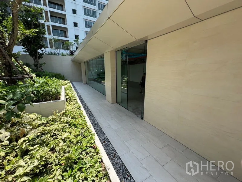 零售空间 出租在Pathum Wan, Bangkok - 玻璃立面沿铺装步道，旁为景观花槽。