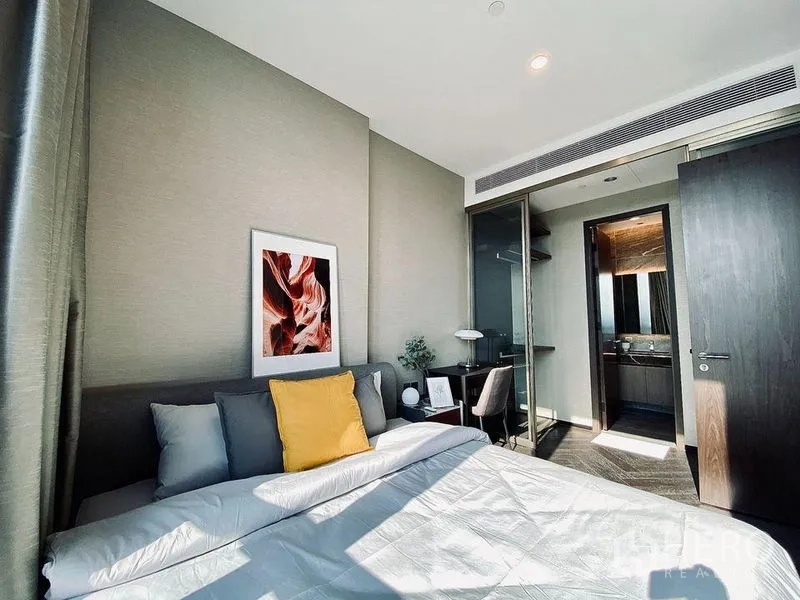 Condominium for rent in Khlong Toei, Bangkok - Bright bedroom leading to an en-suite bathroom, built-in closet, and neutral décor.