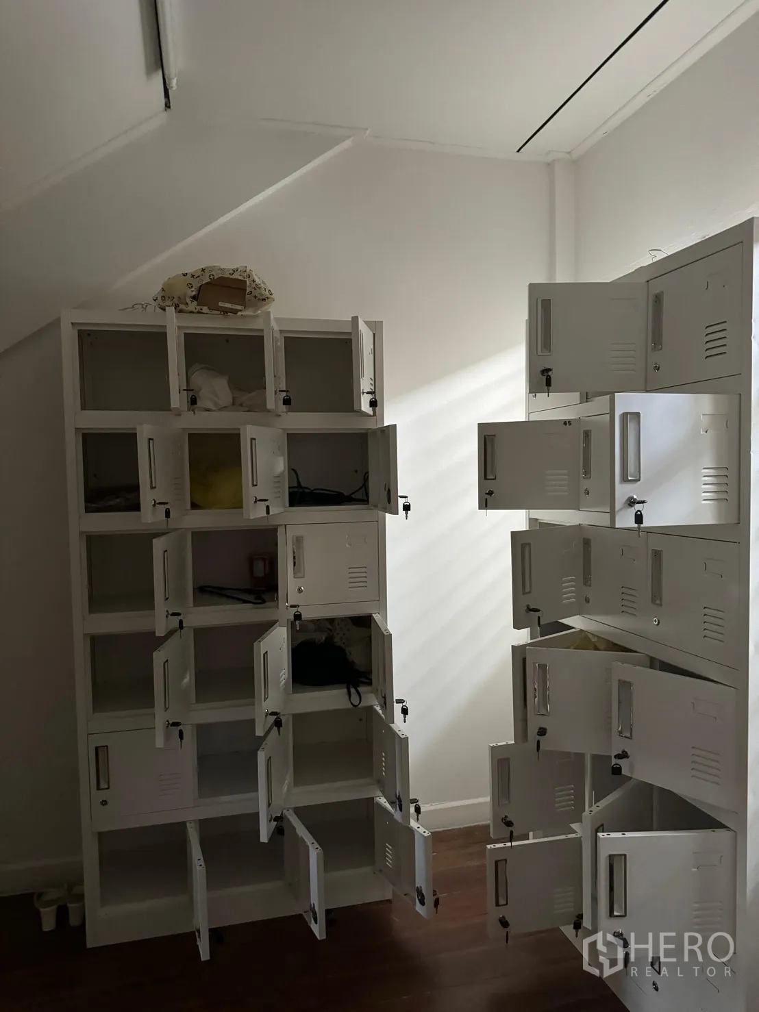 อาคารพาณิชย์ ให้เช่าในBangkok - ห้องเก็บของพร้อมตู้ล็อกเกอร์โลหะสีขาว ใต้ฝ้าเพดานลาด พื้นไม้