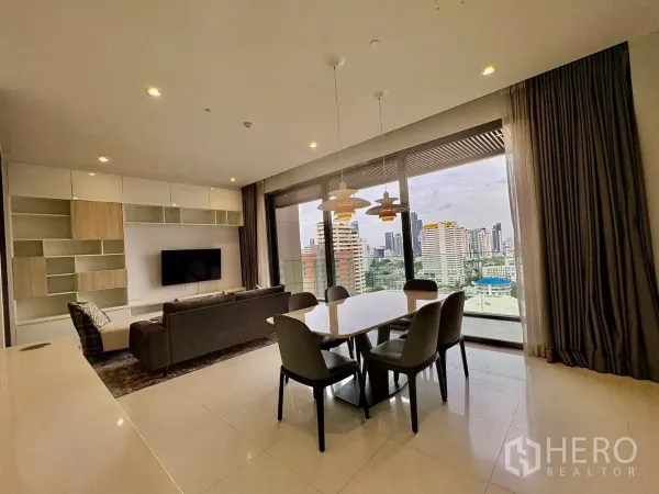 คอนโด ให้เช่าในWatthana, Bangkok - ผนังทีวี โซฟา และชุดรับประทานอาหาร มองออกสู่สกายไลน์ผ่านประตูกระจกบานเลื่อน