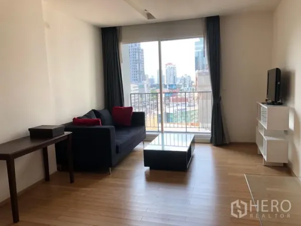 公寓 出租在Khlong Toei, Bangkok - Siri at Sukhumvit客厅明亮，配沙发、茶几、电视柜与阳台，可观城市景观，靠近通罗。