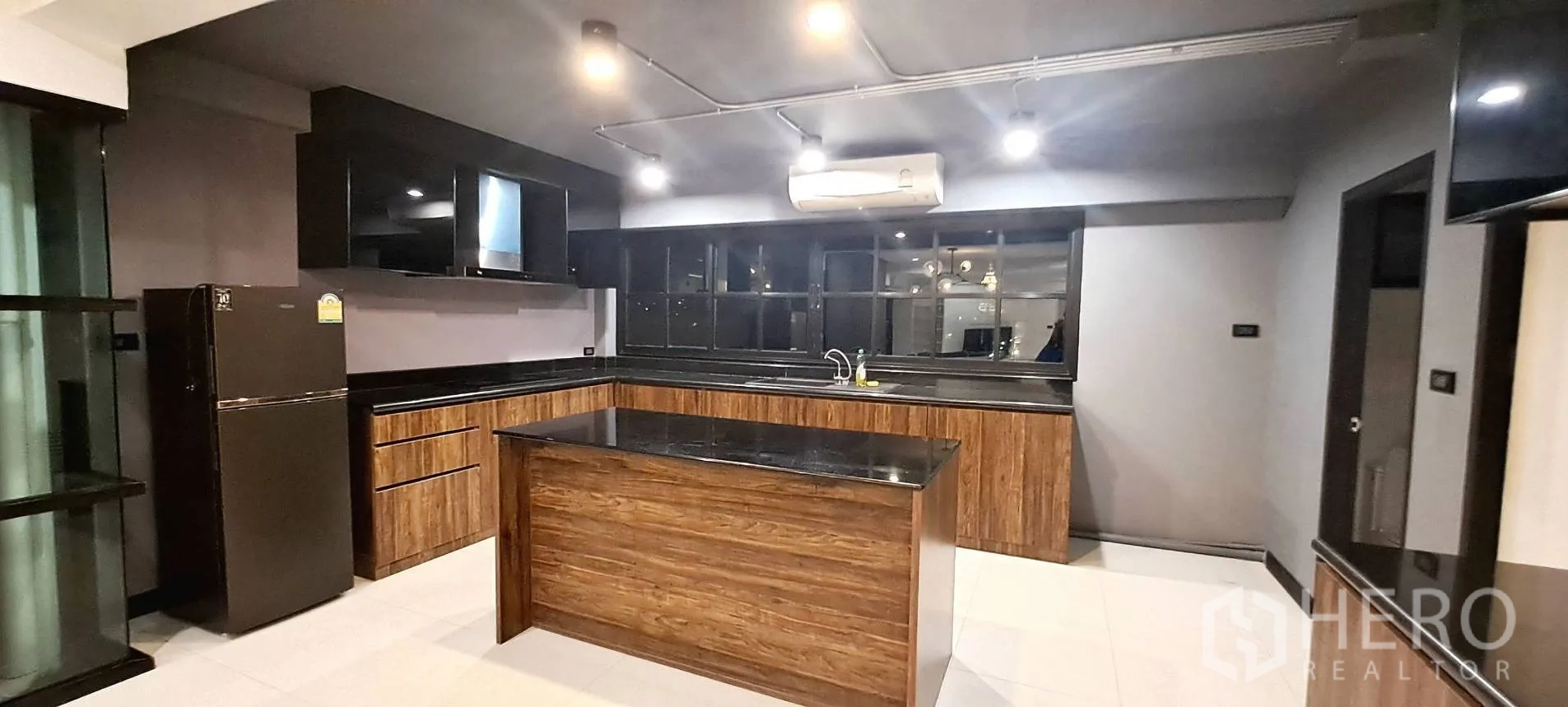 Apartment for rent in Phra Khanong, Bangkok - Walk-in closet with extensive white shelving and hanging rails.
