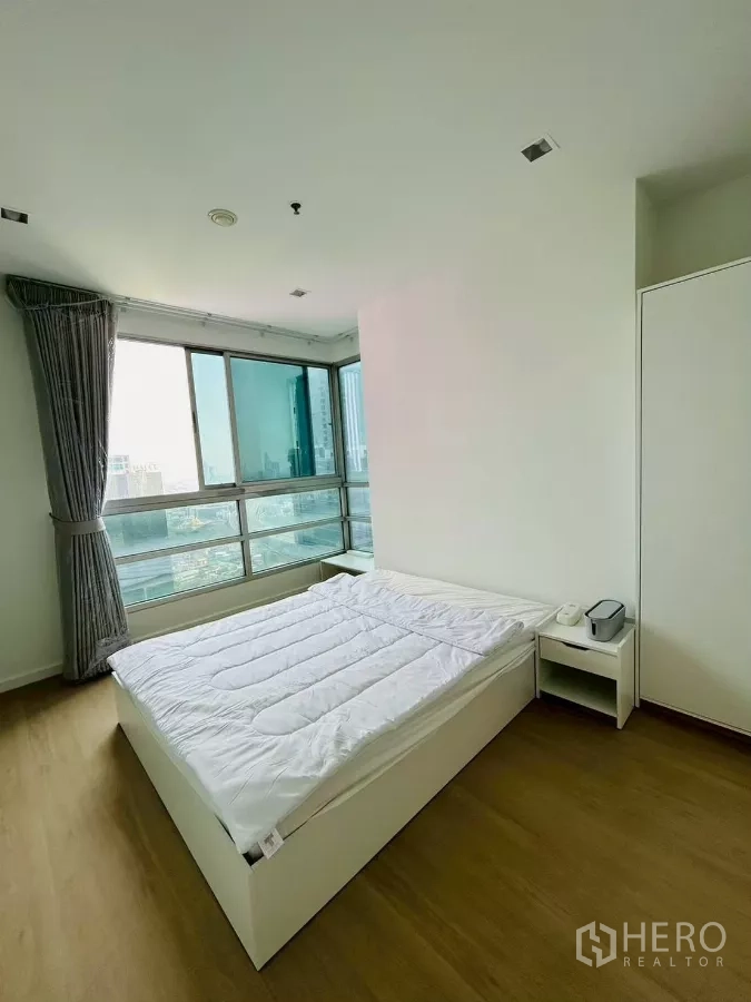 公寓 出租在Bang Rak, Bangkok - 转角主卧，环窗设计，白色床品，尽览沙吞天际线。