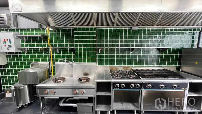 อาคารพาณิชย์ ให้เช่า - เตาแก๊ส เตาย่าง และฮูดดูดควันยาว บนผนังกระเบื้องสีเขียวมันเงา