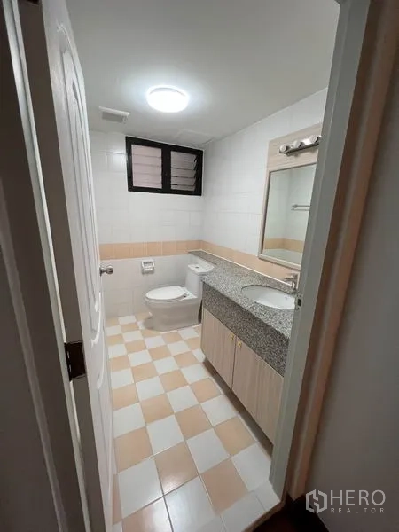 公寓 出租或出售在Watthana, Bangkok - 卫生间配花岗岩台面、镜子与坐便器，棋盘格地砖。