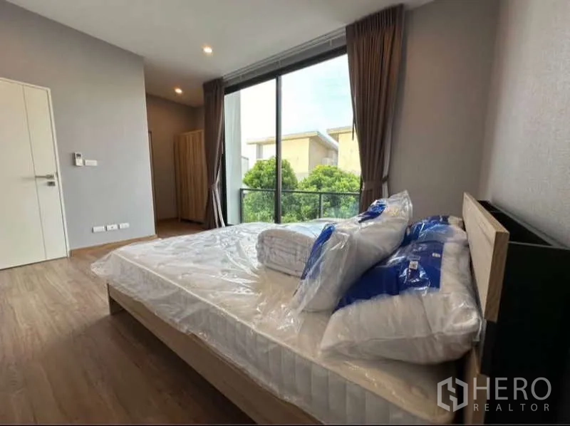 联排别墅 出租在Lat Phrao, Bangkok - 主卧配推拉落地门通向阳台，景观面向花园。