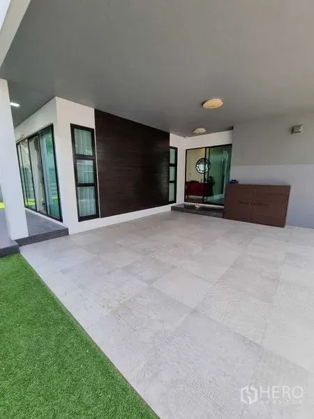 独立式住宅 出租或出售在Prawet, Bangkok - 带顶露台/车位，瓷砖地面，旁有玻璃推拉门与草坪。