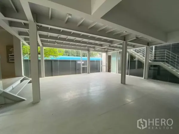 Home Office for rent in Watthana, Bangkok - Open-plan ground floor with high ceiling, support columns and floor-to-ceiling glass walls.