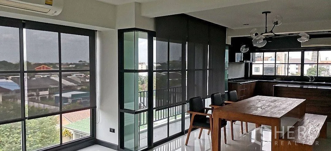 Apartment for rent in Phra Khanong, Bangkok - Large bedroom with upholstered bed, curtains, and air conditioning.