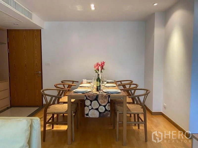 公寓 出租或出售在Phra Khanong, Bangkok - 用餐区摆放六人木餐桌和椅子，顶部射灯照明。