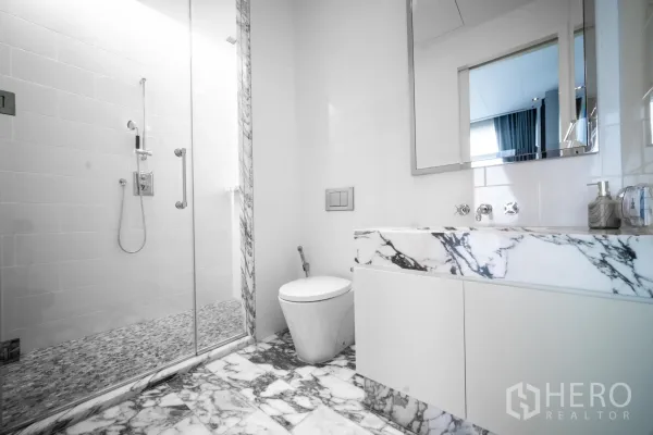 公寓 出租在Bang Rak, Bangkok - 邦拉区豪华公寓浴室，配大理石台面、玻璃淋浴与马赛克地面。