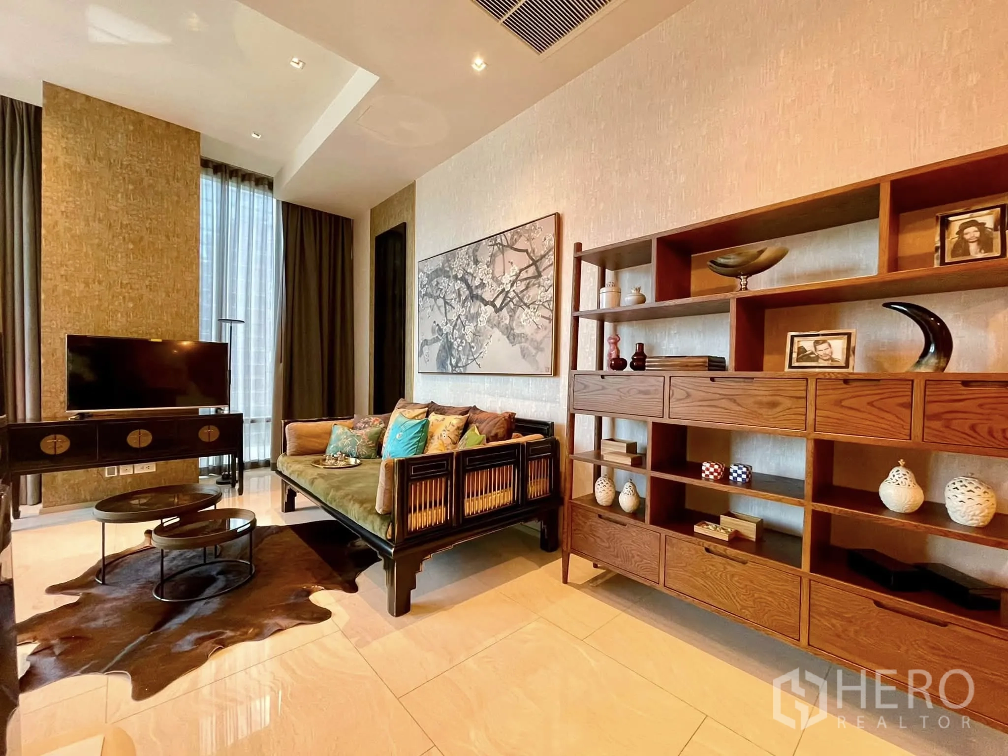 Condominium for rent in Bang Rak, Bangkok - Living room detail with TV stand, decorative shelving and sofa.