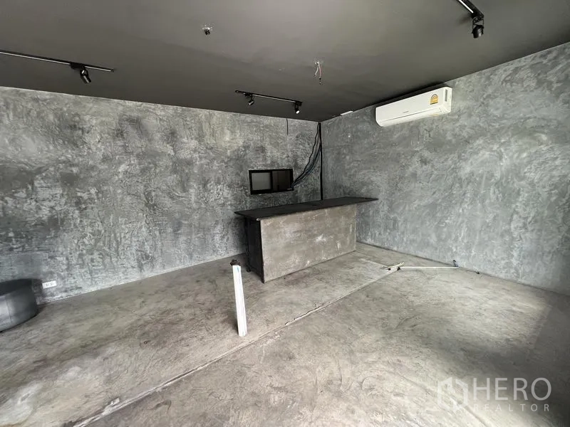 零售空间 出租在Watthana, Bangkok - 水泥质感的零售内饰，设服务台、轨道灯和壁挂空调。