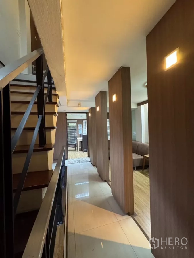 店屋 出租在Bang Rak, Bangkok - 长走廊与楼梯，发光木柱引导至起居空间。