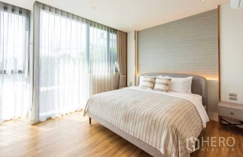 คอนโด ให้เช่าในBang Na, Bangkok - ห้องนอนสว่างด้วยเตียงคิง ผนังตกแต่ง ผ้าม่านโปร่ง และพื้นโทนไม้