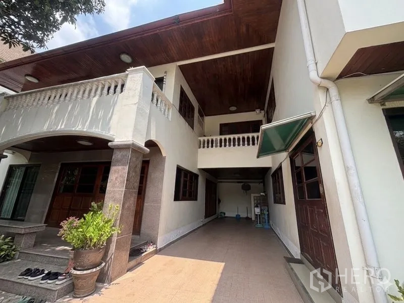 独栋房屋 for sale in Suan Luang, Bangkok - 房屋侧立面，有顶车位、拱廊与阳台栏杆。