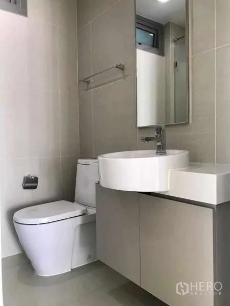 คอนโด ให้เช่าในBang Kho Laem, Bangkok - ห้องน้ำที่สองมีอ่างล้างหน้าทรงกลม กระจก และราวแขวนผ้าโทนสีอบอุ่น.