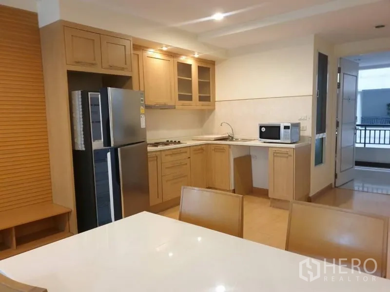 คอนโด ให้เช่าในWatthana, Bangkok - ครัวโทนไม้สว่าง มีตู้ลอย เตา ไมโครเวฟ และตู้เย็นสองประตู