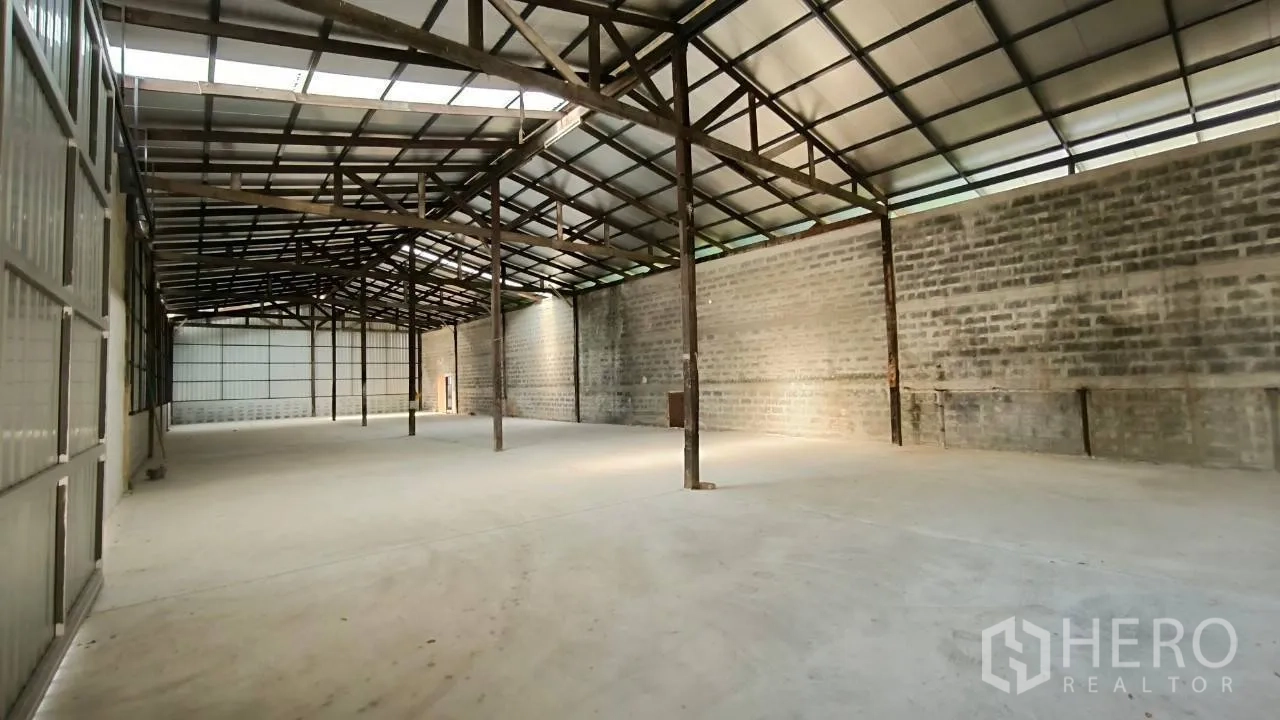 Factory for rent in Mueang Samut Prakan, Samut Prakan - Large interior bay with block walls, steel trusses, and wide clear floor area.